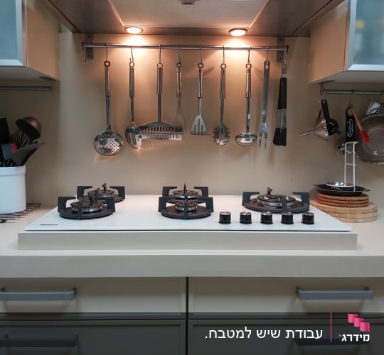 מטבח עם משטח שיש לבן וכיריים גז